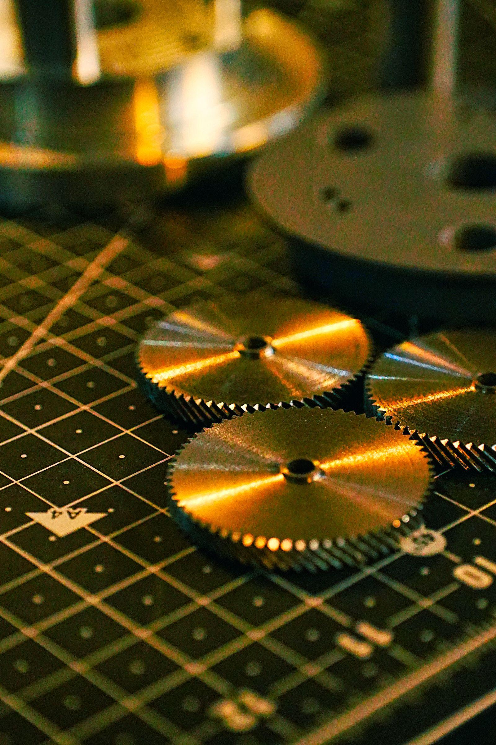Small steel gears laid out on a marked work mat